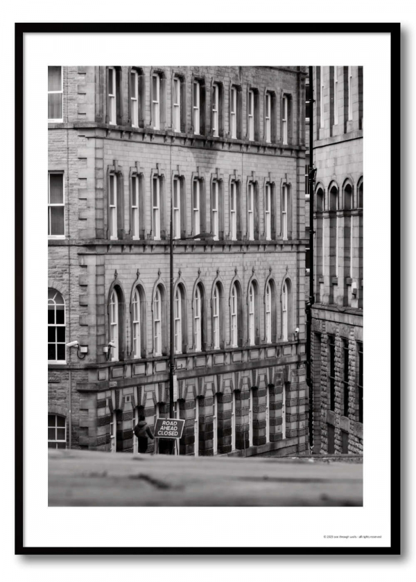 Black and white urban geometry photography print – Victorian arched façade with lone figure beside Road Ahead Closed sign at street level