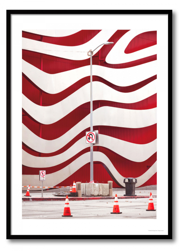 Los Angeles architecture photography print of the Petersen Museum's undulating red and white wave facade with traffic cones and no-entry signs in the foreground